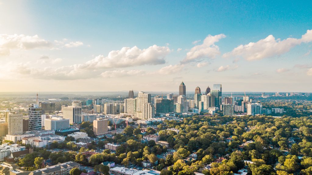 City View of Atlanta with green trees in the foreground. Bird eye perspective on a sunny day with few clouds.