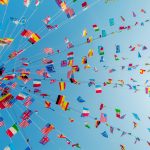 International flags blowing against the sky in a clear summer afternoon