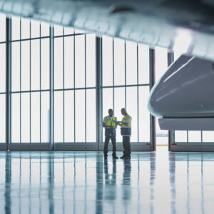 Air traffic control in hangar Air traffic control ground crew workers talking in airplane hang