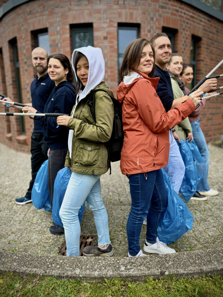 Picture of spairliners colleagues in front of our office building equipped with trash bags and tweezers ready to clean up for earth day 2026